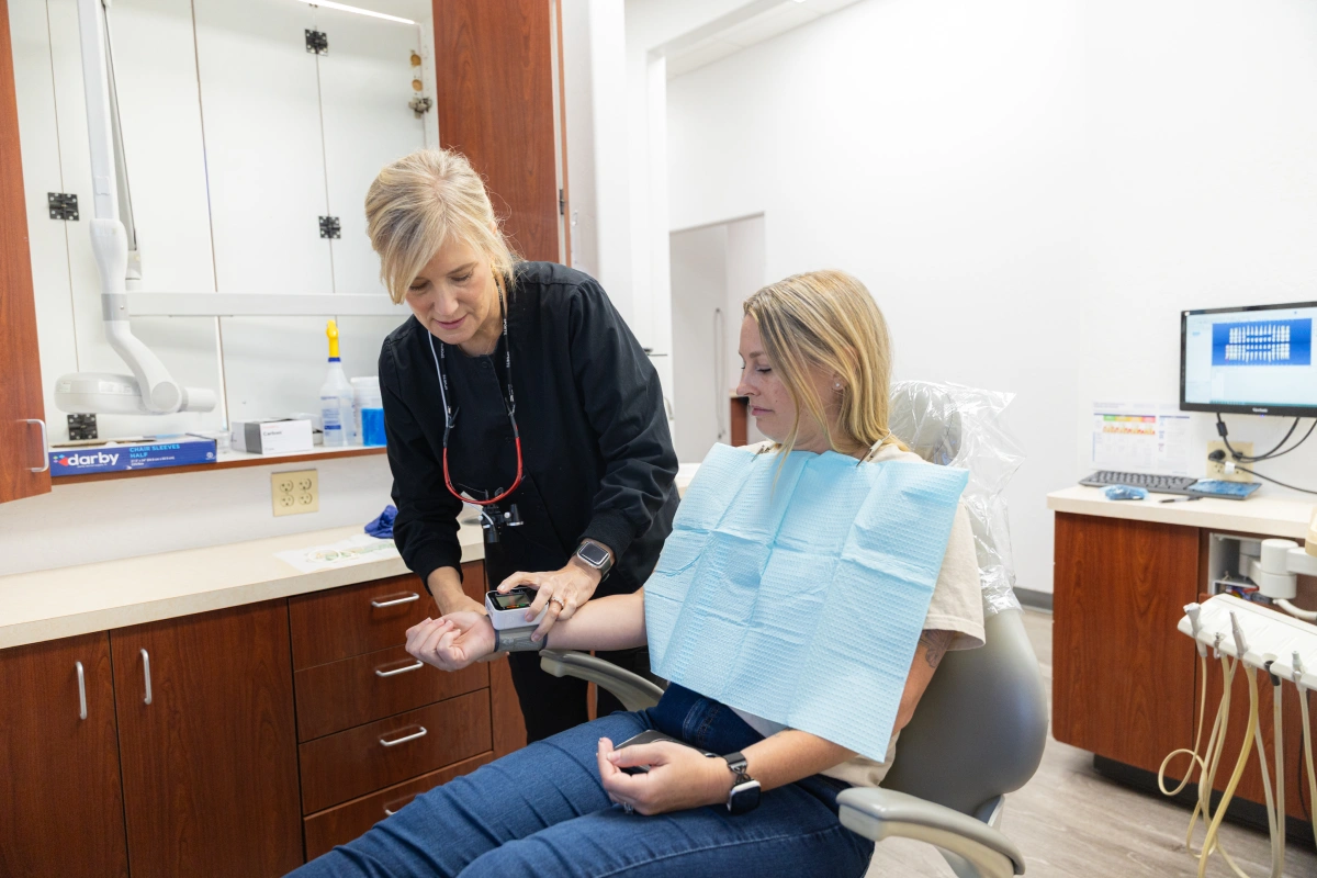 Dentist showing patient dental X-rays in modern dental office treatment room.