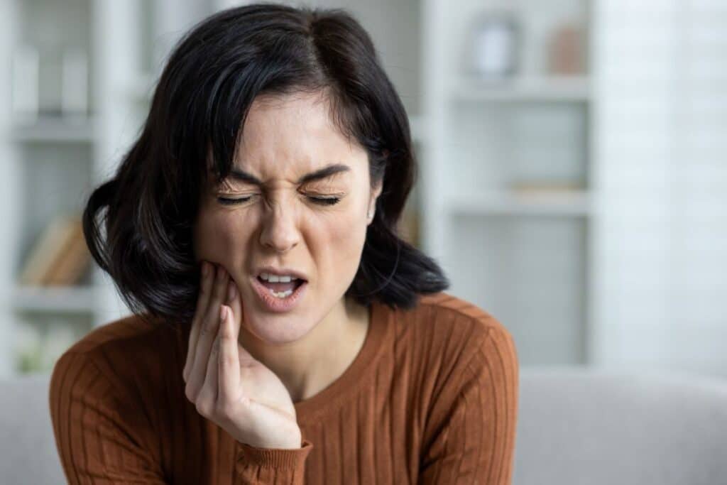 Patient experiencing tooth pain from an untreated cavity before Dental Fillings Gilbert treatment.